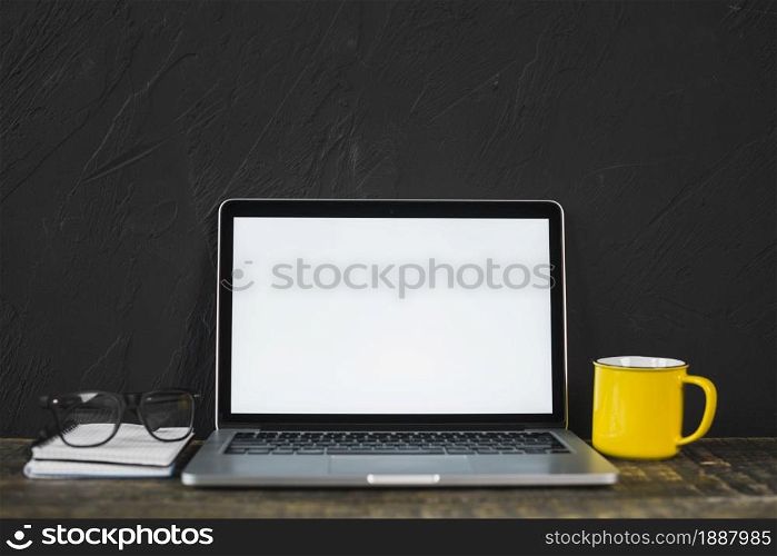 laptop spectacle yellow coffee mug diary table with black textured wall . Resolution and high quality beautiful photo. laptop spectacle yellow coffee mug diary table with black textured wall . High quality and resolution beautiful photo concept