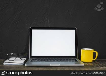 laptop spectacle yellow coffee mug diary table with black textured wall . Resolution and high quality beautiful photo. laptop spectacle yellow coffee mug diary table with black textured wall . High quality and resolution beautiful photo concept