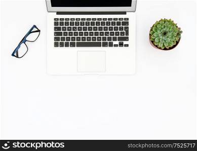 Laptop, succulent plants and glasses on white background. Office workplace. Flat lay mock up