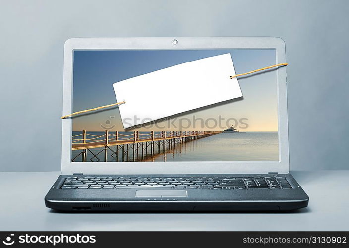 laptop with blank note on blue background