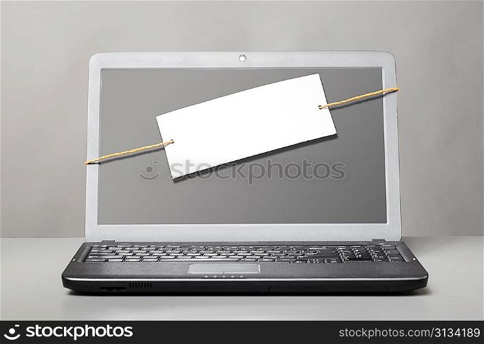 laptop with blank note on gray background