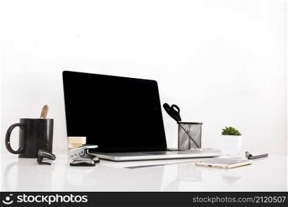 laptop with blank screen cellphone reflective desk