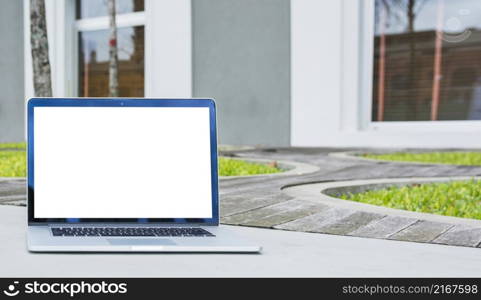 laptop with blank screen front house