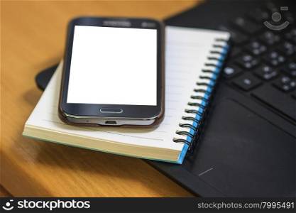 Laptop with book and smartphone on work desk
