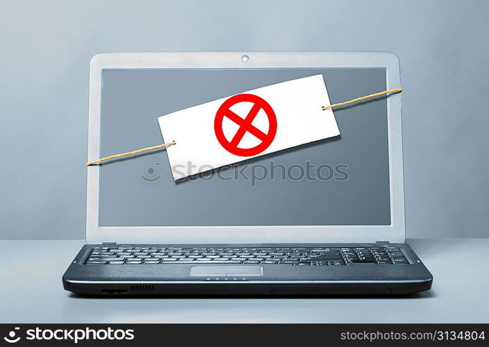 laptop with deny sign on blue background