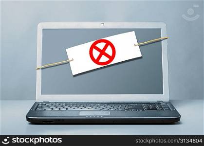 laptop with deny sign on blue background