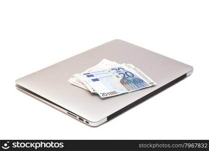 Laptop With Euro money isolated on white