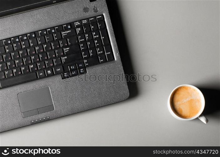 laptop with fresh cup of coffee, view from above
