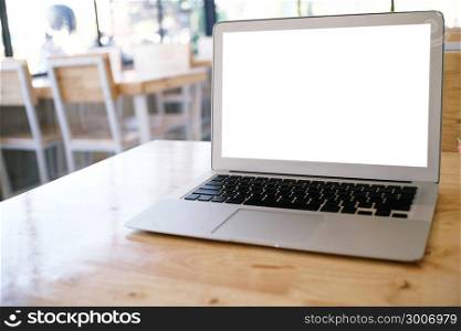 Laptop with Mock up blank screen on wooden table in front of coffeeshop cafe space for text. product display montage- technology concept.