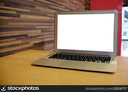 Laptop with Mock up blank screen on wooden table in front of coffeeshop cafe space for text. product display montage- technology concept.