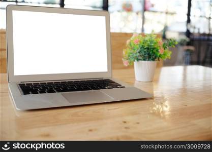 Laptop with Mock up blank screen on wooden table in front of coffeeshop cafe space for text. product display montage- technology concept.