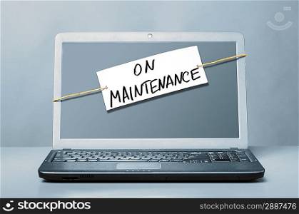 laptop with note about maintenance