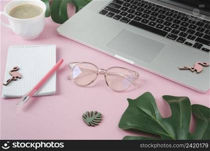 laptop with notebook small flamingos pink table
