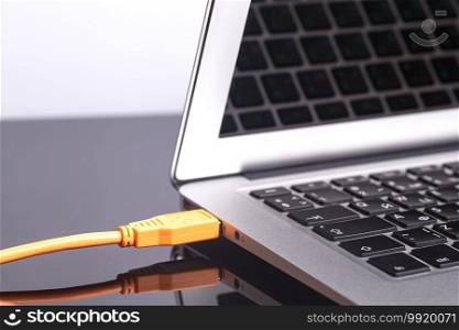 laptop with orange rolled cable.. laptop with orange rolled cable