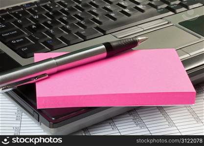 Laptop with spreadsheet,note pad and pen
