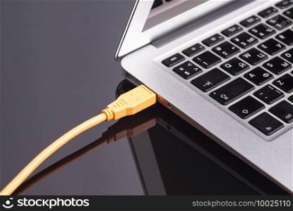 laptop with USB orange cable.. laptop with USB orange cable