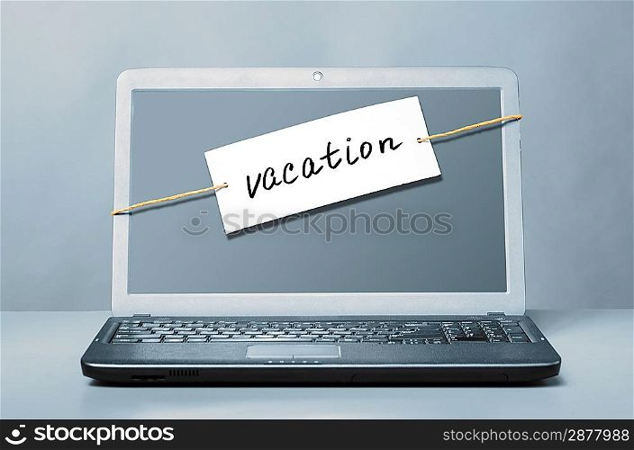 laptop with vacation note on blue background