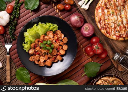 Larb Sausage with Chili Spring onions and lettuce in a black plate. Selective focus.