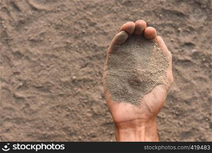 Large amounts of dust in men's hands, dry soil.