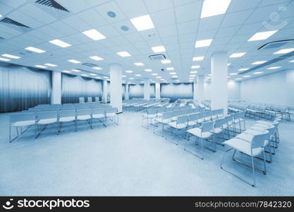 large and modern white auditorium with blue curtains