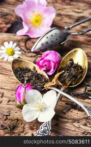 large assortment of herbal teas in tea-spoons on a wooden background. Tea spoons with tea leaves