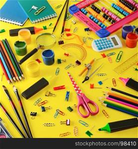 Large assortment school supplies on yellow background. Top view.