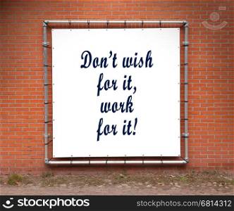 Large banner with inspirational quote on a brick wall - Don't wish for it, work for it!