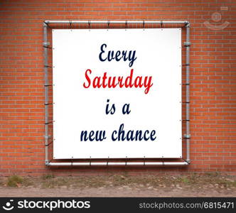 Large banner with inspirational quote on a brick wall - Every saturday is a new chance