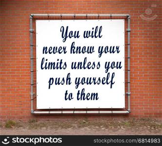 Large banner with inspirational quote on a brick wall - You will never know your limits...
