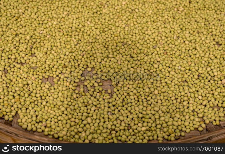 Large basket of green split peas drying inside Tulou in Fujian Province in China. Green split peas drying inside Tulou in Fujian Province