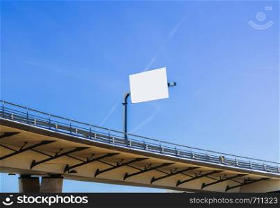 Large blank billboard at highway overpass with blue sky - insert message accordingly. Large blank billboard at highway overpass with blue sky