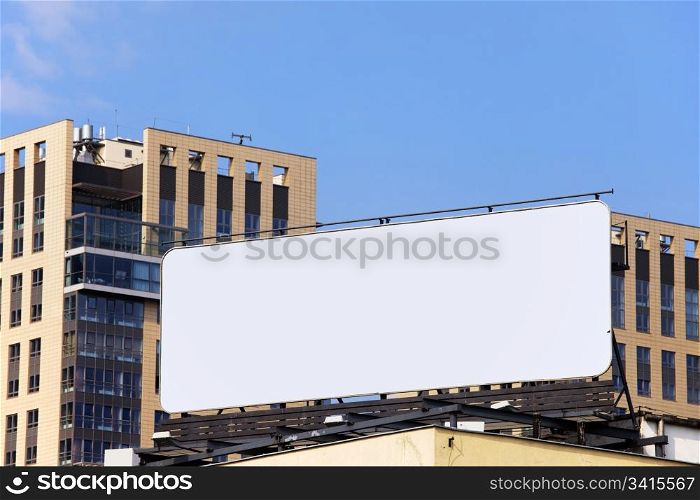 Large blank billboard on a building roof in the city downtown