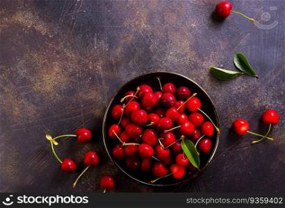Large bowl of bright red cherries on dark background