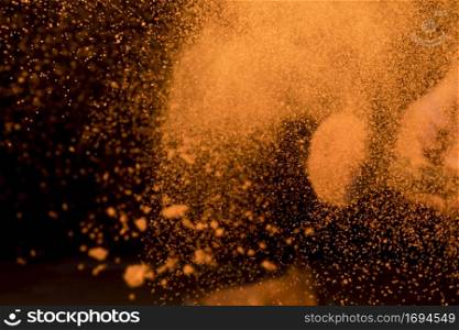 large burst orange makeup powder dark background