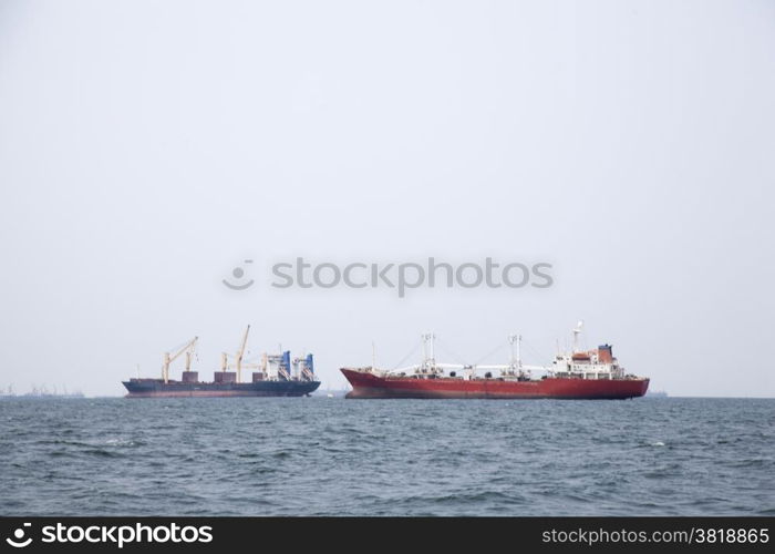 Large cargo ship Boats moored in the sea to make sense compared to the coast.