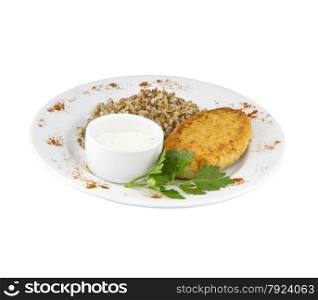 Large chicken cutlet with sauce and buckwheat on a plate with an isolated background. Large chicken cutlet with sauce and buckwheat