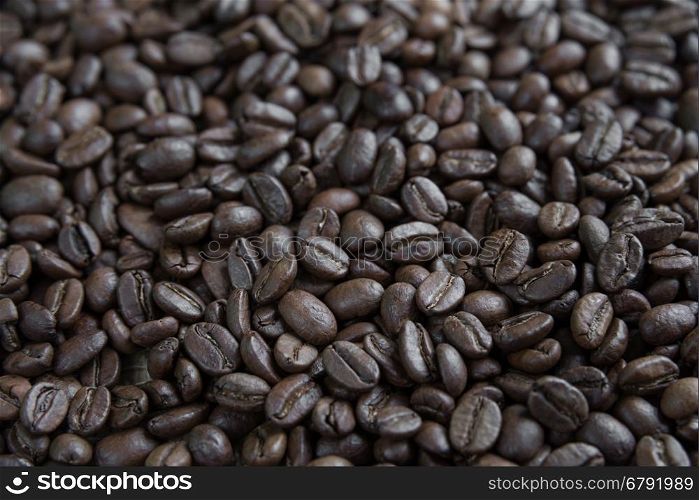 Large coffee background: roasted coffee beans close-up in perspective