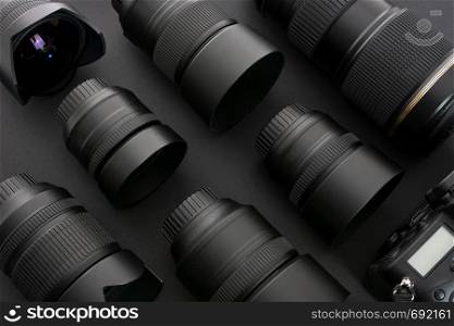 Large collection of professional and modern photographic equipment on a black background (low key).