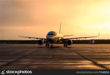 Large commercial aircraft on the runway during sunset. Concept of travel around the world.