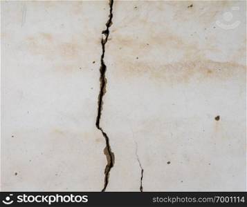 Large crack opening up on plastered wall of old building. Large vertical crack in plastered wall