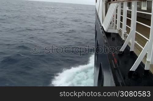 Large cruise ship at open sea. Waves splashing on the side of ship.