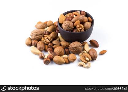 Large diversity of healthy nuts in a dark stone bowl - isolated