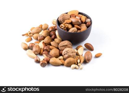 Large diversity of healthy nuts in a dark stone bowl - isolated