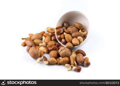Large diversity of healthy nuts in a white bowl - isolated