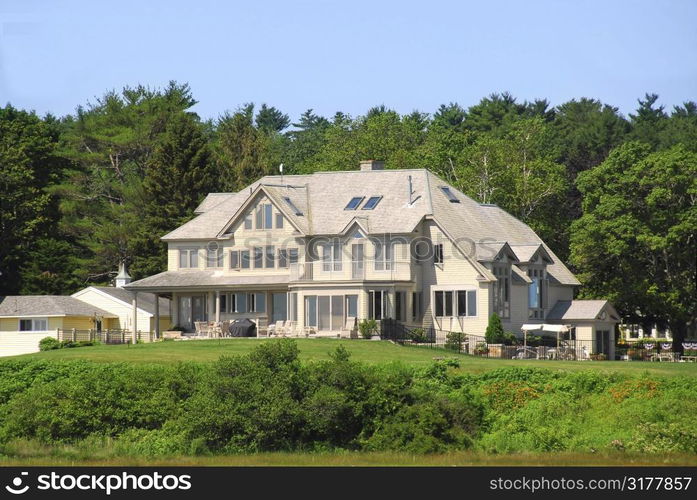 Large executive home surrounded by green trees