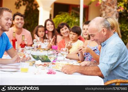 Large Family Group Celebrating Birthday On Terrace Together