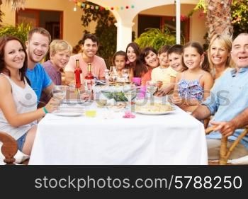Large Family Group Enjoying Meal On Terrace Together