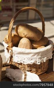 Large fresh potato in a beautiful basket basket.. Large fresh potato in a beautiful basket basket