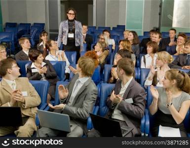 Large Group of Business People Sitting at the Conference Call and Applauding Together to One Businesswoman