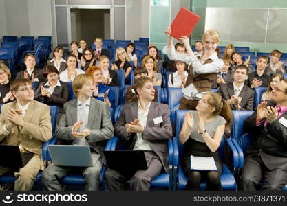 Large Group of Business People Sitting at the Conference Call and Applauding Together to One Businesswoman with an Award.